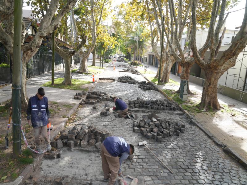 Trabajadores retiran y recolocan adoquines durante tareas de reparación de una calle en Banfield.